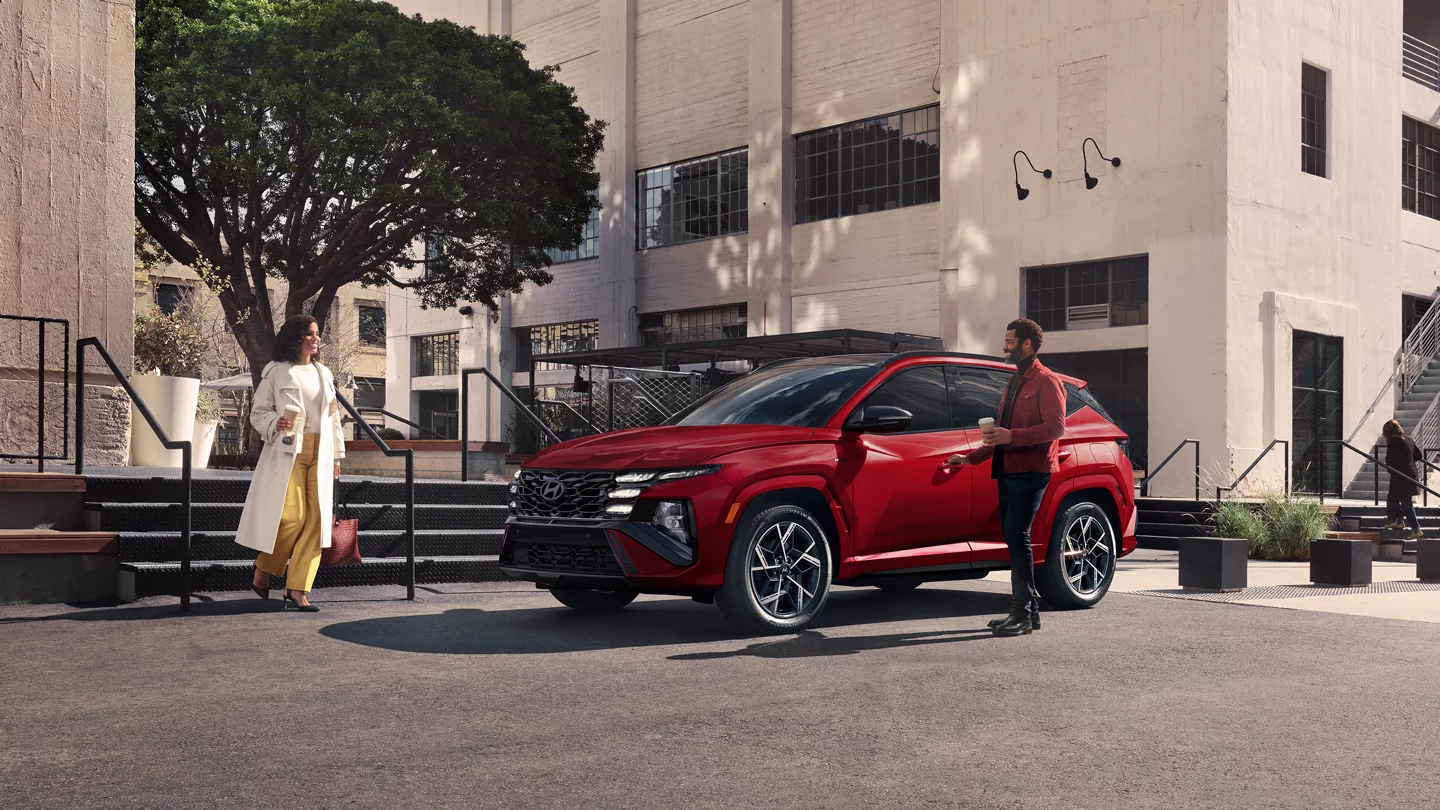 2025 Hyundai Tucson Hybrid in parking lot with young couple