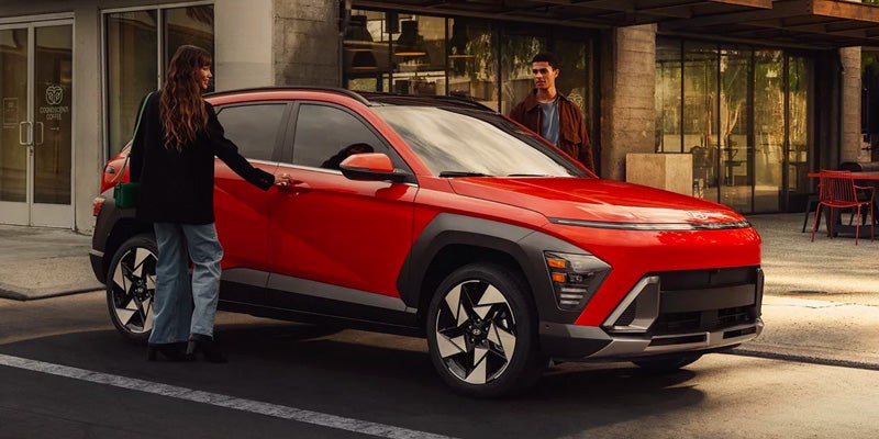Red Hyundai Kona SUV parked in an urban setting with modern exterior styling.