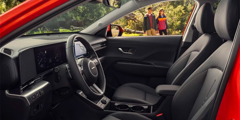 Hyundai Kona interior with front seats, steering wheel, and modern cabin design.