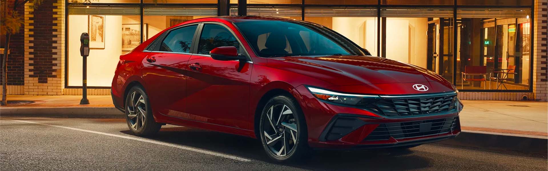 2026 Hyundai Elantra red sedan parked near modern building