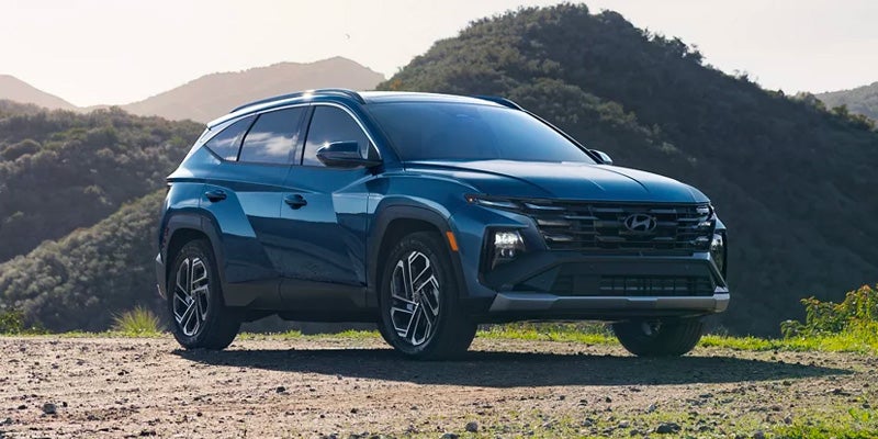 Hyundai Tucson SUV parked outdoors with a scenic mountain landscape in the background.