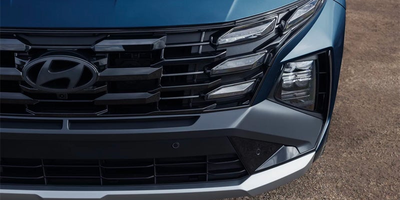 Hyundai Tucson front grille and headlight detail showcasing modern exterior styling.