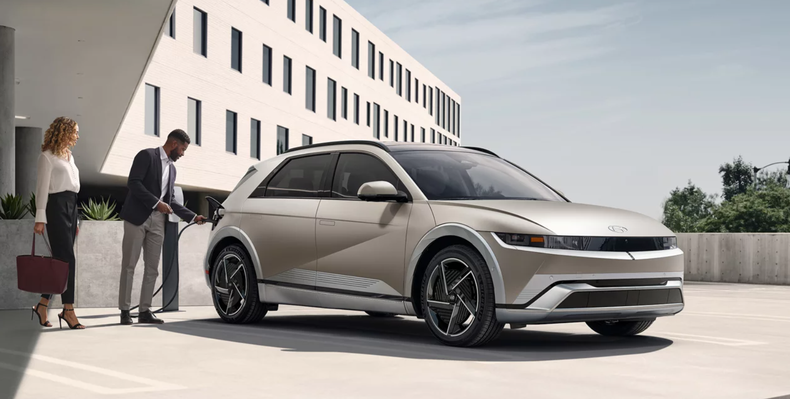 2026 hyundai ioniq 5 being plug in to charge by couple in parking garage.